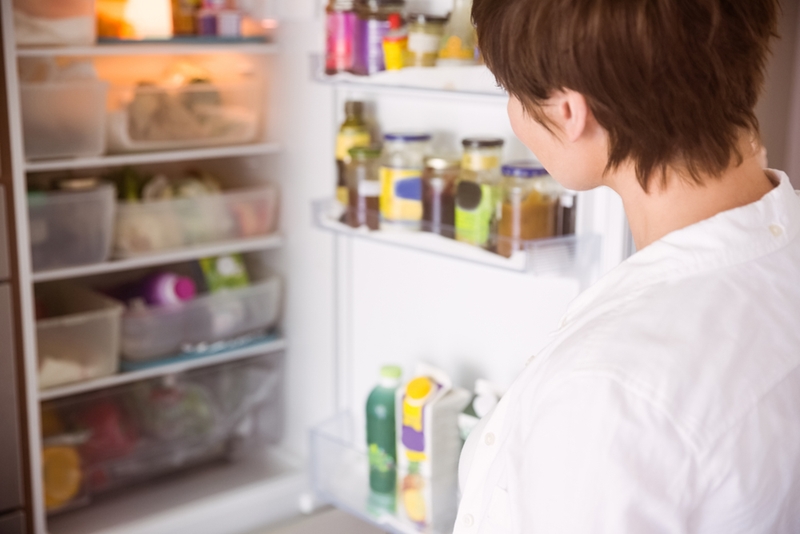 A woman looking in the fridge.